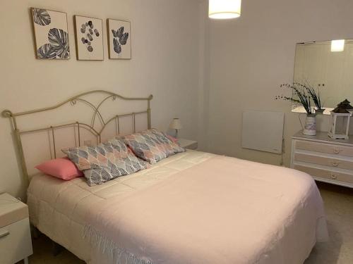 a bedroom with a large white bed and a dresser at Céntrico in Antequera