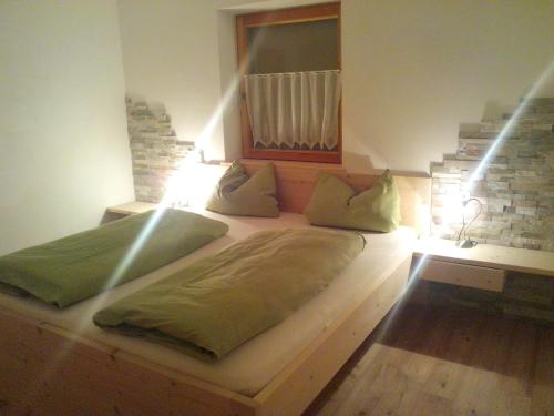 un grande letto in una stanza con una luce sopra di Prestihof a San Vigilio Di Marebbe
