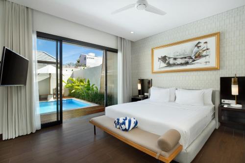 a bedroom with a bed and a pool at The Claremont Luxury Villas in Seminyak