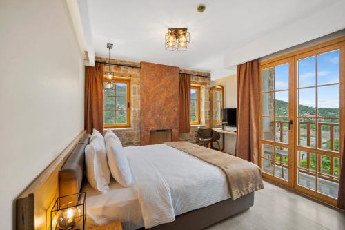 ein Schlafzimmer mit einem großen Bett und großen Fenstern in der Unterkunft ZEYT INN HOTEL in Datca
