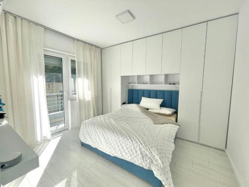 um quarto branco com uma cama e uma janela em Durres Currila SUNSET Beach Beaty em Durrës