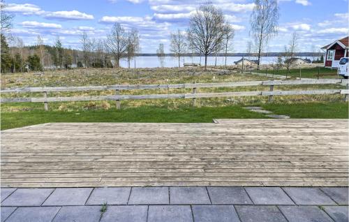 a wooden deck with a fence and a lake at Gorgeous Home In Vittaryd With Wifi in Kvänarp