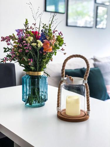 a candle and a vase with flowers on a table at Ferienwohnung Nelia in Lübeck