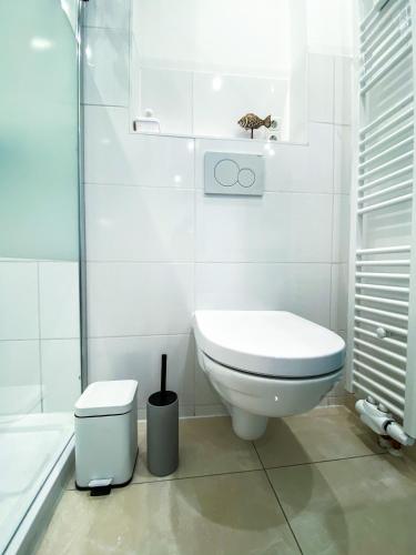 a white bathroom with a toilet and a shower at Ferienwohnung Nelia in Lübeck