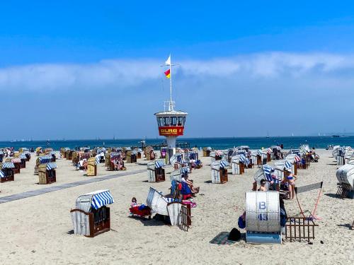 a beach with many chairs and a lifeguard tower at Ferienwohnung Nelia in Lübeck