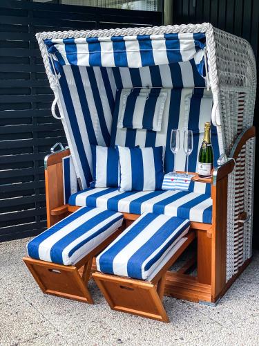 a wicker chair with blue and white striped cushions at Ferienwohnung Nelia in Lübeck