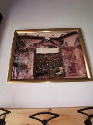 a picture hanging on a wall above a table at Curt da Beta - Casa vacanze con giardino, in Corte del XVIII secolo in Malnate