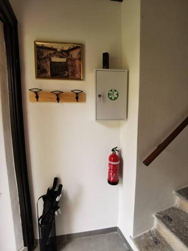 a hallway with a wall with a clock and a umbrella at Curt da Beta - Casa vacanze con giardino, in Corte del XVIII secolo in Malnate