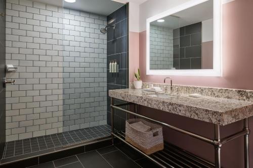 a bathroom with a sink and a mirror at Renaissance Saint Elm Dallas Downtown Hotel in Dallas