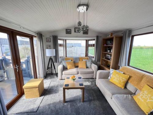 a living room with two couches and a table at Lancaster Lodge, Coningsby, Lincolnshire. in Coningsby