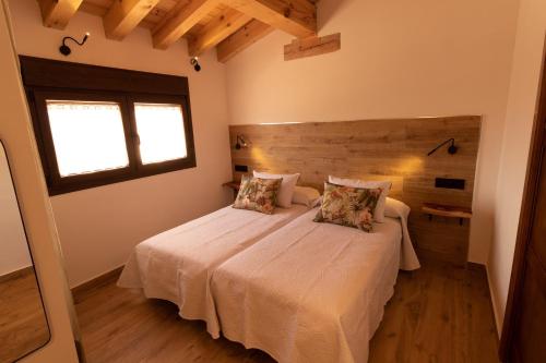1 dormitorio con 2 camas y ventana en Casas Las Hazas, en La Cuesta
