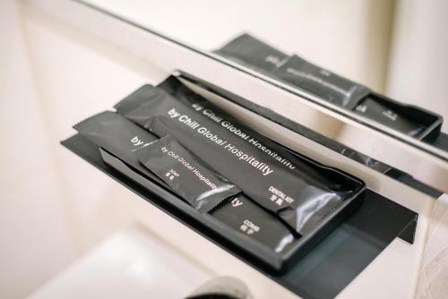 a pile of black makeup products sitting on a shelf at The Concept Hotel KL - Batu Caves in Batu Caves