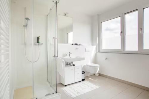 a white bathroom with a shower and a sink at Beautiful room with balcony direction to Messe in Hannover