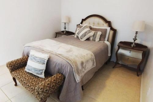 a bedroom with a large bed and a chair at Home from Home 5 bedroom villa in Davenport
