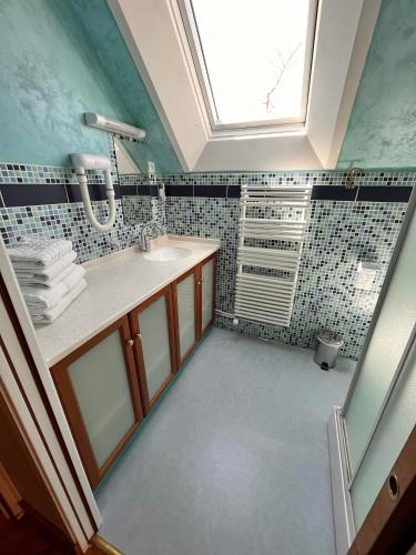 a bathroom with a sink and a skylight at La ferme du paradis in Merris