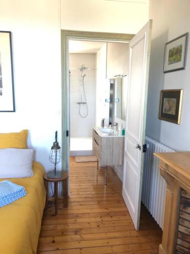 a bedroom with a bed and a bathroom with a sink at La Chambre de L'Embarcadère in Le Conquet