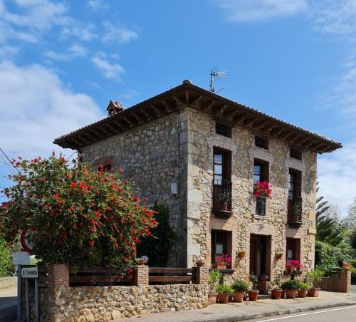 a stone building with flowers in front of it at La Torruca in Oreña
