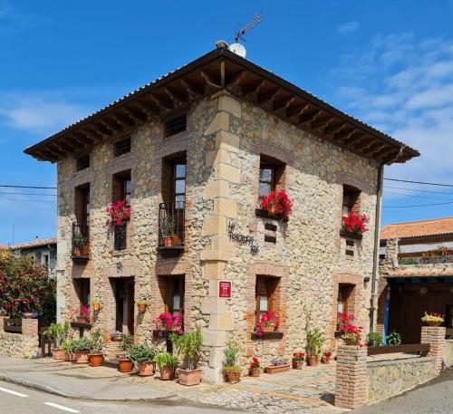 a stone building with potted plants on it at La Torruca in Oreña