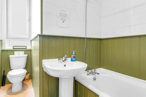 La salle de bains est pourvue d'un lavabo, de toilettes et d'une baignoire. dans l'établissement spacious flat, close to the city centre with scenic views, à Édimbourg