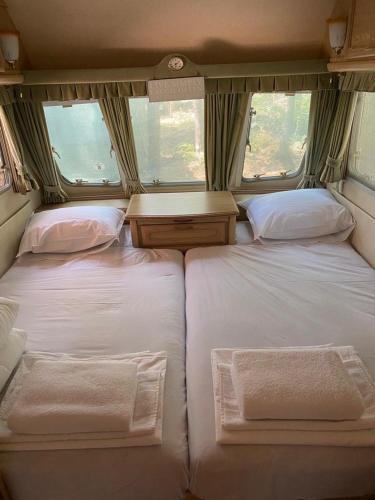 a bedroom with two beds and a table in an rv at Delightful Beach & Forest Caravan in Chernomorets