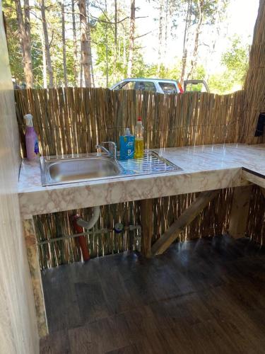 a kitchen with a sink and a wooden fence at Delightful Beach & Forest Caravan in Chernomorets