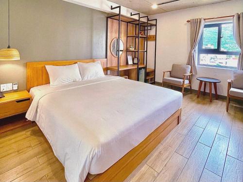 a bedroom with a large bed and a table and chairs at Coast House Boutique Hotel in Nha Trang