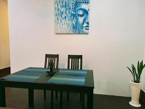 mesa de comedor con 2 sillas y una pintura en Strawberry Swing Homestay, en Guwahati