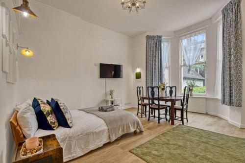 - une chambre avec un lit, une table et des chaises dans l'établissement Charming Apartment Earls Court, à Londres