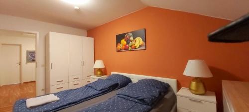 a bedroom with two beds and an orange wall at Stilvolles Haus 124 qm in Balingen