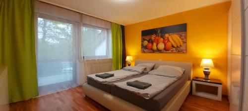バーリンゲンにあるStilvolles Haus 124 qmのフルーツの写真が飾られたベッド1台が備わるベッドルーム1室が備わります。
