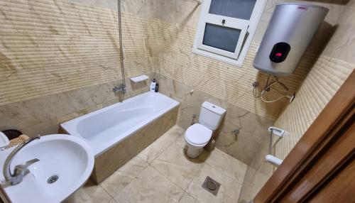 a bathroom with a sink and a toilet and a bath tub at Sea View Heart Apartment (families only) in Alexandria