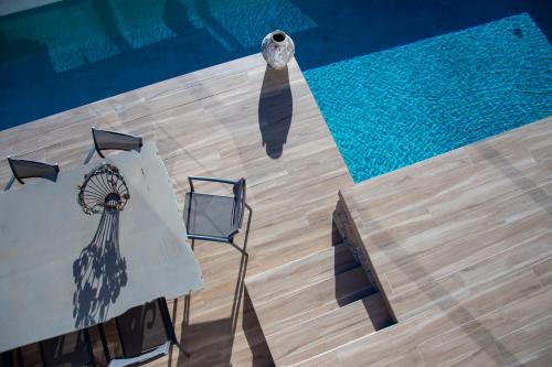 an overhead view of a pool with two chairs and a table at The Boatyard Luxury Villa in Tzíkidhes