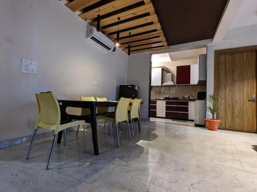 a dining room with a table and yellow chairs at Back Stayz Hostel in Rishīkesh