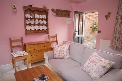 a living room with a couch and a table at The Gardener's Cottage in Leominster