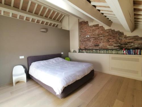 a bedroom with a bed and a brick wall at CasaDei Sweet Home Design & Relax - Beach Parking in Cervia