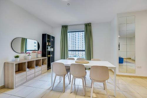 a dining room with a table and chairs and a mirror at Big Apartment in Murjan, JBR, near the beach in Dubai