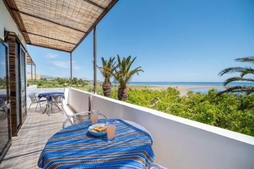 una mesa en un balcón con vistas al océano en Milos studios & Beach House, en Frangokastello