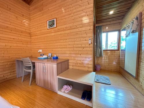 Habitación con escritorio en una cabaña de madera en Shunde Palm Resort 仙本那顺德人家棕榈园, en Semporna