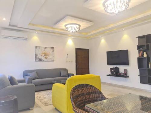 a living room with a couch and a tv at Khalda Rooftop Apt. in Amman