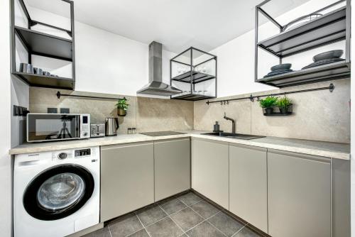 a kitchen with a washing machine and a sink at Emirates Sports Hotel, Dubai Sports City in Dubai