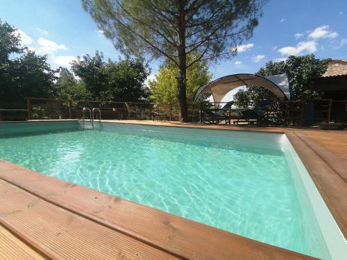 einen großen Pool mit Holzterrasse in der Unterkunft Gîte du Fassac in Saint-Julien-du-Puy