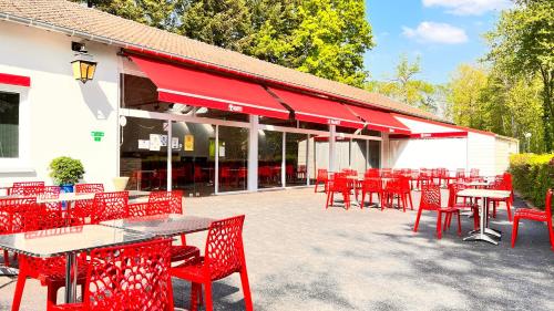 a group of red tables and chairs in front of a building at Camping Country Park Touquin - Site Officiel - Next to Disneyland Paris in Touquin