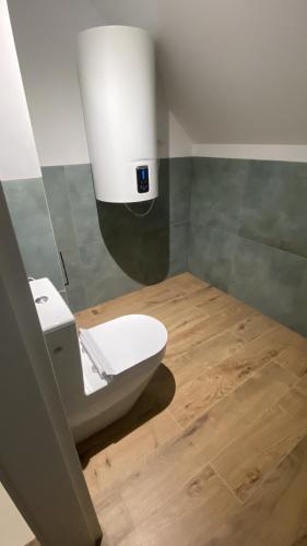 ein weißes WC im Bad mit Holzboden in der Unterkunft PORTKNAUBER in Rowy