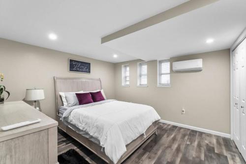 um quarto com uma cama grande e almofadas roxas em Elegant 1-BR Apartment em Silver Spring