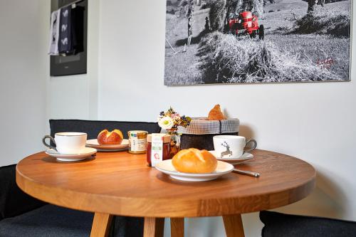 a wooden table with cups and plates of food on it at Schittlerhaus in Oberstdorf