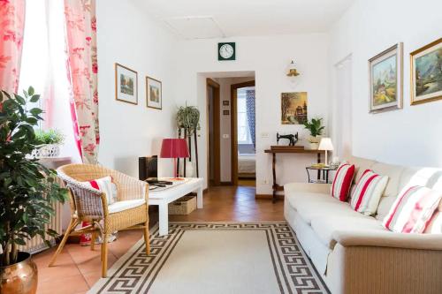 a living room with a white couch and a desk at TRENTINO LODGE Via San Vito in Strigno