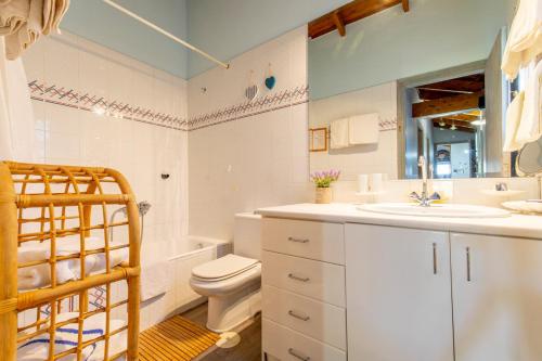 a bathroom with a toilet and a sink and a tub at Iliachtida House in Sounio