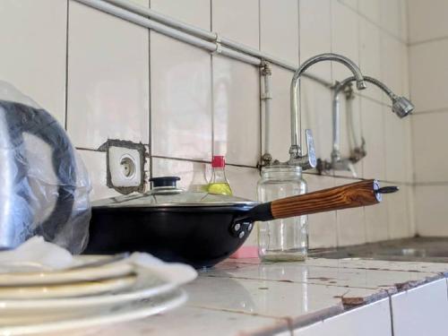 um balcão de cozinha com um lavatório com uma faca em FIIAA em Iaundé