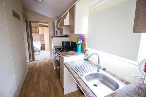 uma cozinha com um lavatório e uma bancada em 6 Berth Caravan With Free Wifi For Hire In Suffolk Ref 68073bs em Lowestoft