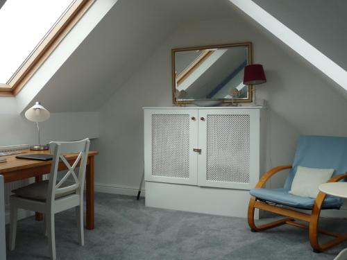 um quarto com uma secretária, um espelho e uma cadeira em Gwyndaf Holiday Cottage em Llangoed